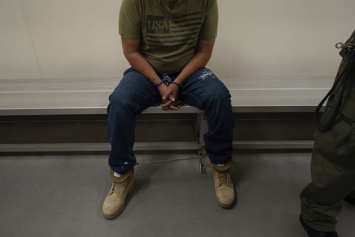 Un inmigrante aguarda a ser procesado por agentes de inmigración en un centro de detención migratorio en Los Ángeles