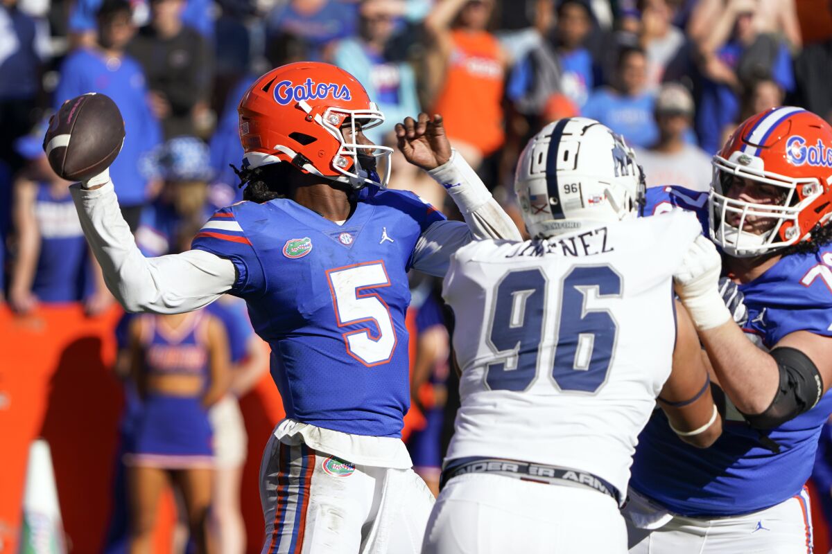 Florida quarterback Emory Jones (5) throws a pass as he is pressured by Samford defensive tackle Francisco Jimenez (96) during the second half of an NCAA college football game, Saturday, Nov. 13, 2021, in Gainesville, Fla. (AP Photo/John Raoux)