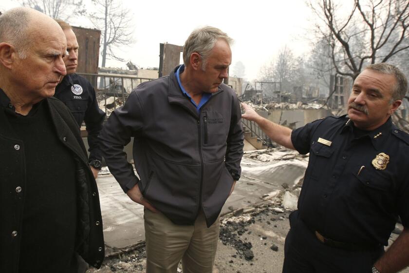 FILE - In this Wednesday, Nov. 14, 2018 file photo, Scott Upton, right, the chief of the Northern Region for the California Department of Forestry and Fire Protection briefs California Gov. Jerry Brown, Federal Emergency Management Agency Director Brock Long, second left, and U.S. Secretary of the Interior Ryan Zinke, third left, during a a tour of the fire ravaged Paradise Elementary School in Paradise, Calif. Authorities are searching for those who perished and those who survived the fiercest of wildfires ahead of a planned visit Saturday by President Donald Trump. Democrats Brown and governor-elect Gavin Newsom said they welcomed the president's visit and "now is a time to pull together for the people of California." (AP Photo/Rich Pedroncelli, File)