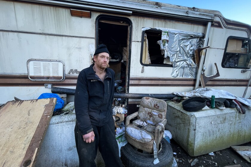 Paul Hunter, a homeless man in Portland, stands outside his RV.