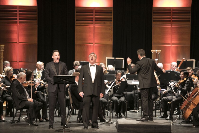 Tenor Stephen Costello, left, and baritone Stephen Powell perform a duet while conductor Bruce Stasyna leads the San Diego Symphony in a dual recital presented by San Diego Opera Wednesday night at the Balboa Theatre.