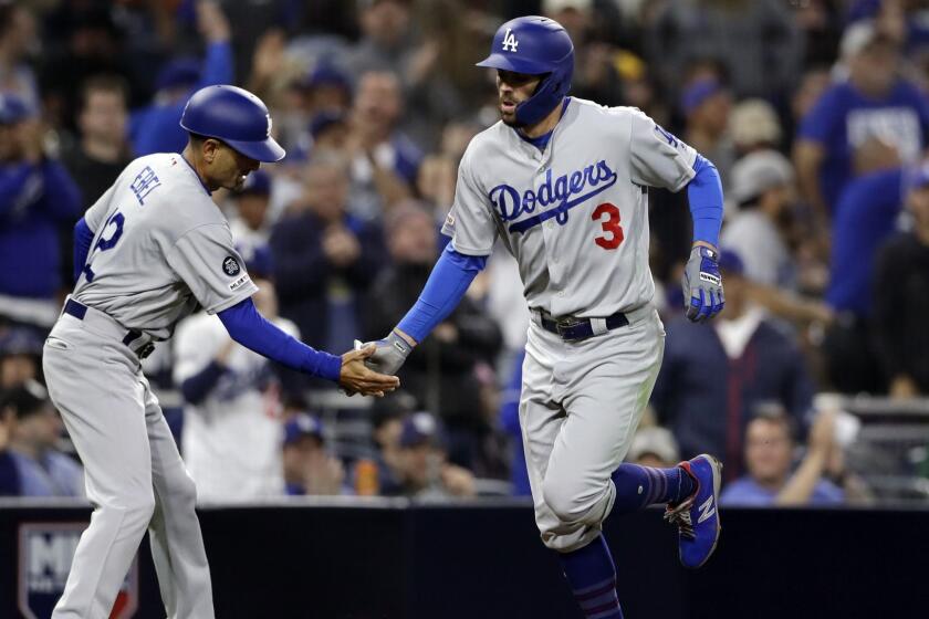 Los Angeles Dodgers' Chris Taylor (3) is greeted by third base coach Dino Ebel after Taylor's home run during the fifth inning of the team's baseball game against the San Diego Padres, Friday, May 3, 2019, in San Diego. (AP Photo/Gregory Bull)