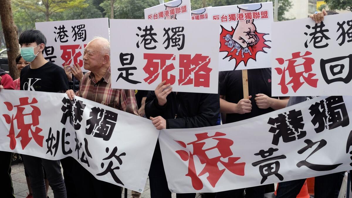 Protesters display anti-Hong Kong and anti-Taiwan independence banners outside a political forum hosted by Taiwan's New Power Party in Taipei on Saturday.