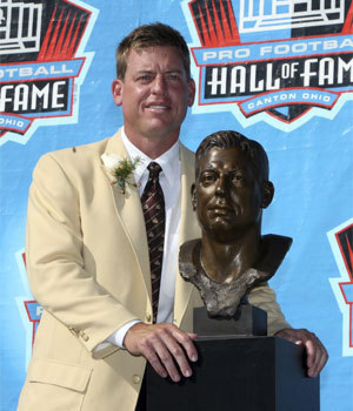 Former Dallas quarterback Troy Aikman poses with his bust after his induction during the Class of 2006 Pro Football Hall of Fame enshrinement ceremony.