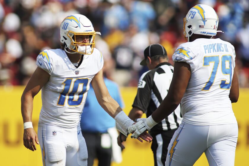 Los Angeles Chargers quarterback Justin Herbert (10) and Los Angeles Chargers offensive tackle Trey Pipkins.