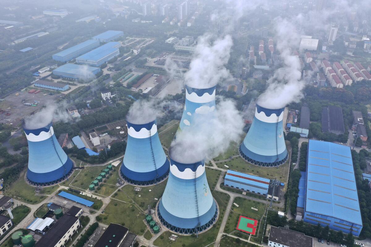 An aerial view of five cooling towers at a power plant.