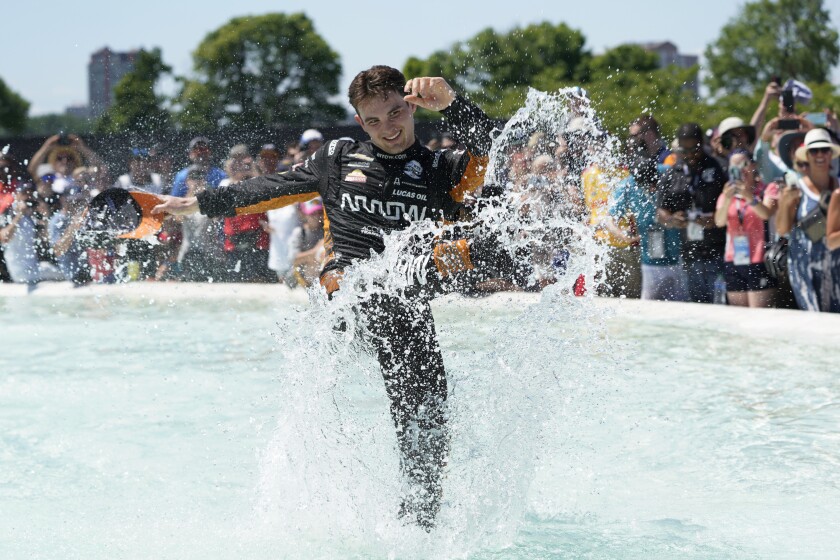 Pato O'Ward celebrates by jumping into James Scott Memorial Fountain after winning the second race of the IndyCar Detroit Grand Prix auto racing doubleheader on Belle Isle in Detroit Sunday, June 13, 2021. (AP Photo/Paul Sancya)