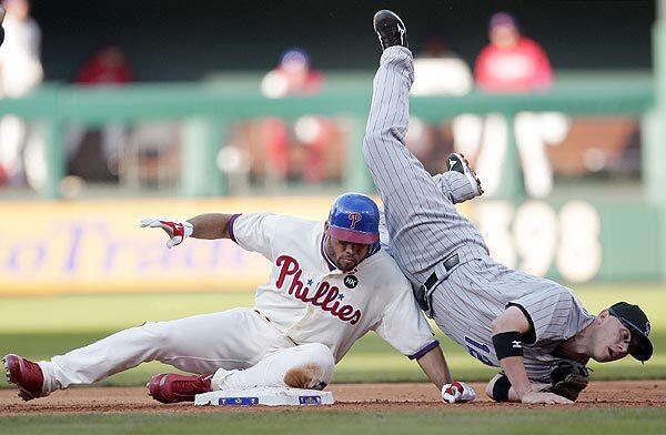 Colorado Rockies second baseman Clint Barmes tumbles over Pedro Feliz of the Philadelphia Phillies while turning a double play in Game 2 of the National League Division Series playoffs. Colorado won the game, 5-4, to even up the series at one game each.