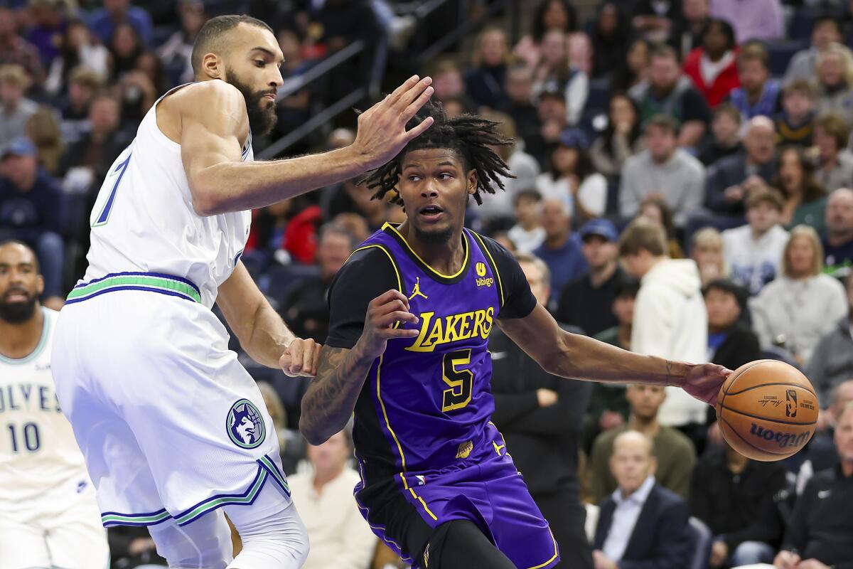 Lakers forward Cam Reddish drives against Minnesota Timberwolves center Rudy Gobert during the second half.