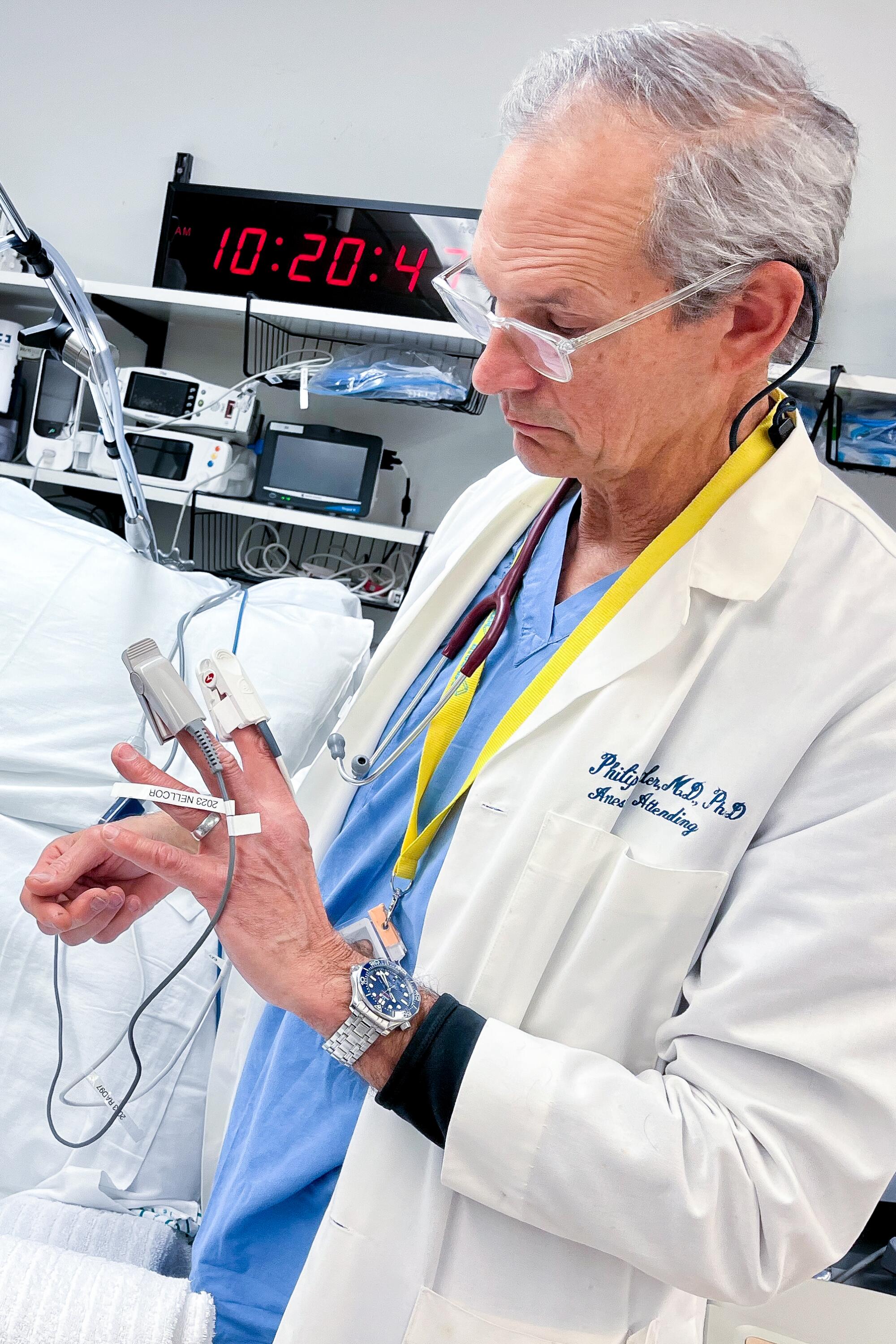  Dr. Phil Bickler examines a pair of pulse oximeters attached to his fingers.