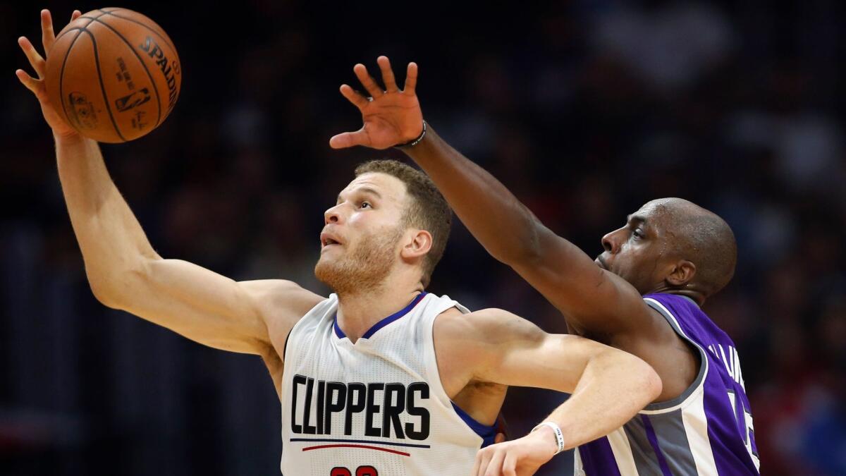 Clippers' Blake Griffin, left, pulls in a pass in front of Sacramento's Anthony Tolliver on March 26.