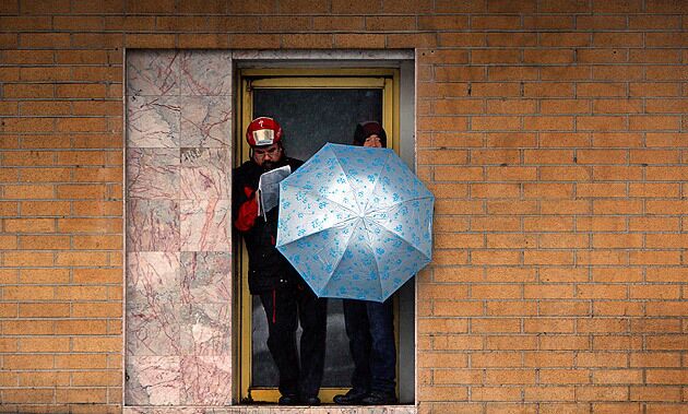 Pedestrians shelter from a passing storm in a doorway along Broadway in Chinatown. See full story