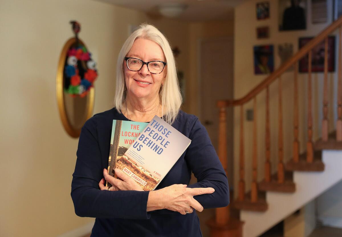 Huntington Beach author Mary Camarillo stands with her novel, "Those People Behind Us."
