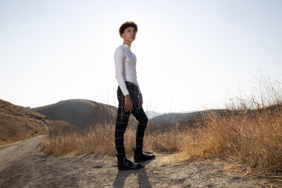 Joshua Caleb Johnson stands on a Southern California hill amid dry brush.