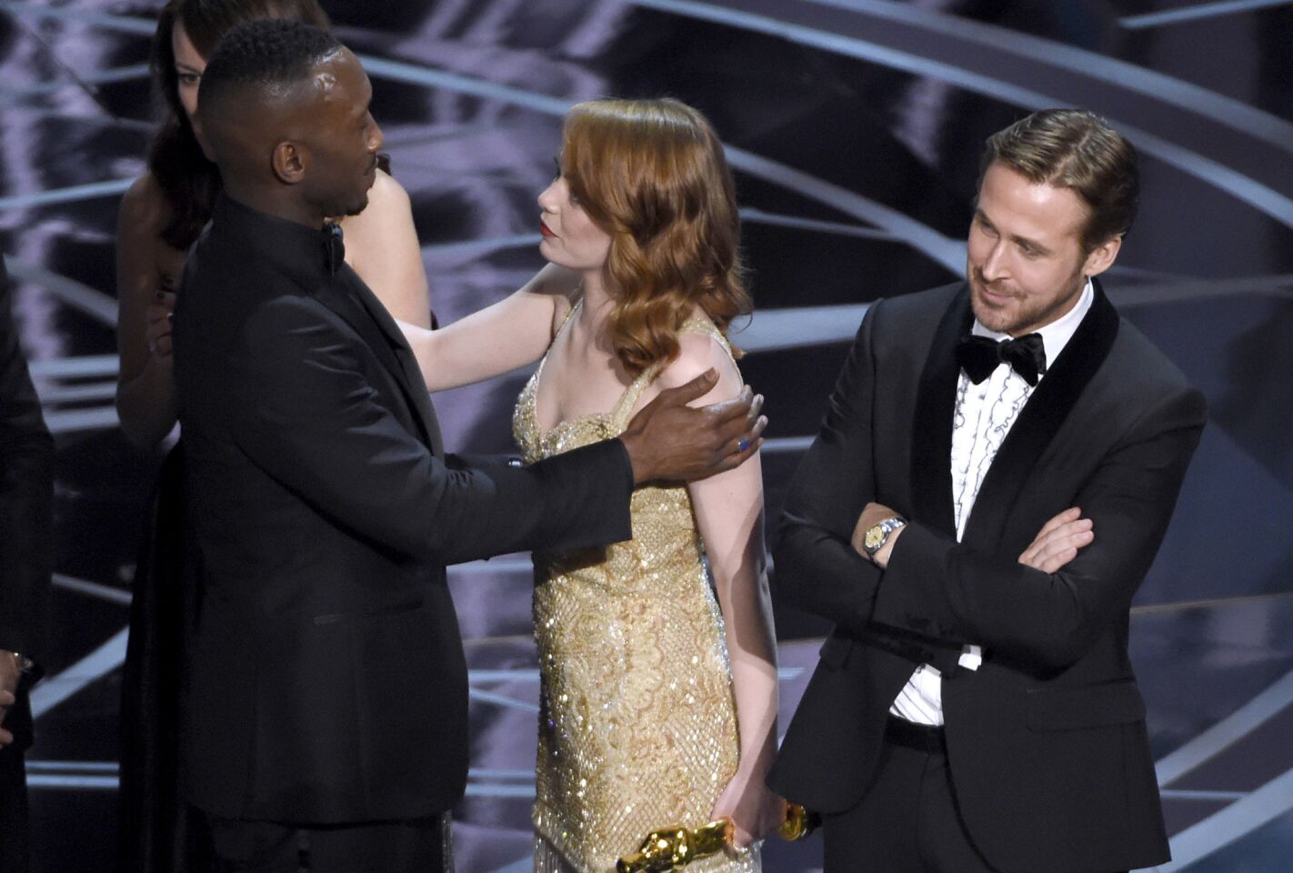 Ryan Gosling, right, stands with arms folded as Emma Stone congratulates Mahershala Ali of "Moonlight."