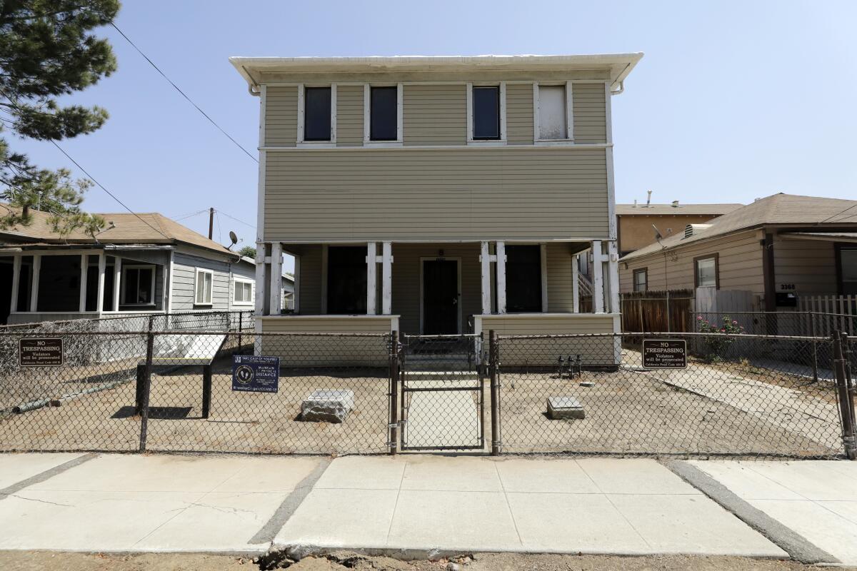 A frontal view of a wooden, clapboard house painted in putty shade.