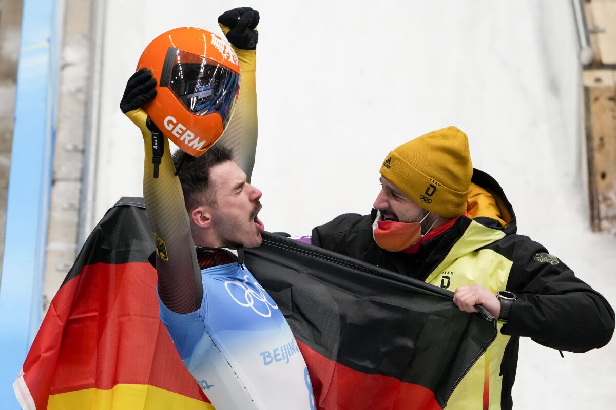 Axel Jungk, of Germany, celebrate winning the silver medal in the men's skeleton at the 2022 Winter Olympics, Friday, Feb. 11, 2022, in the Yanqing district of Beijing. (AP Photo/Dmitri Lovetsky)