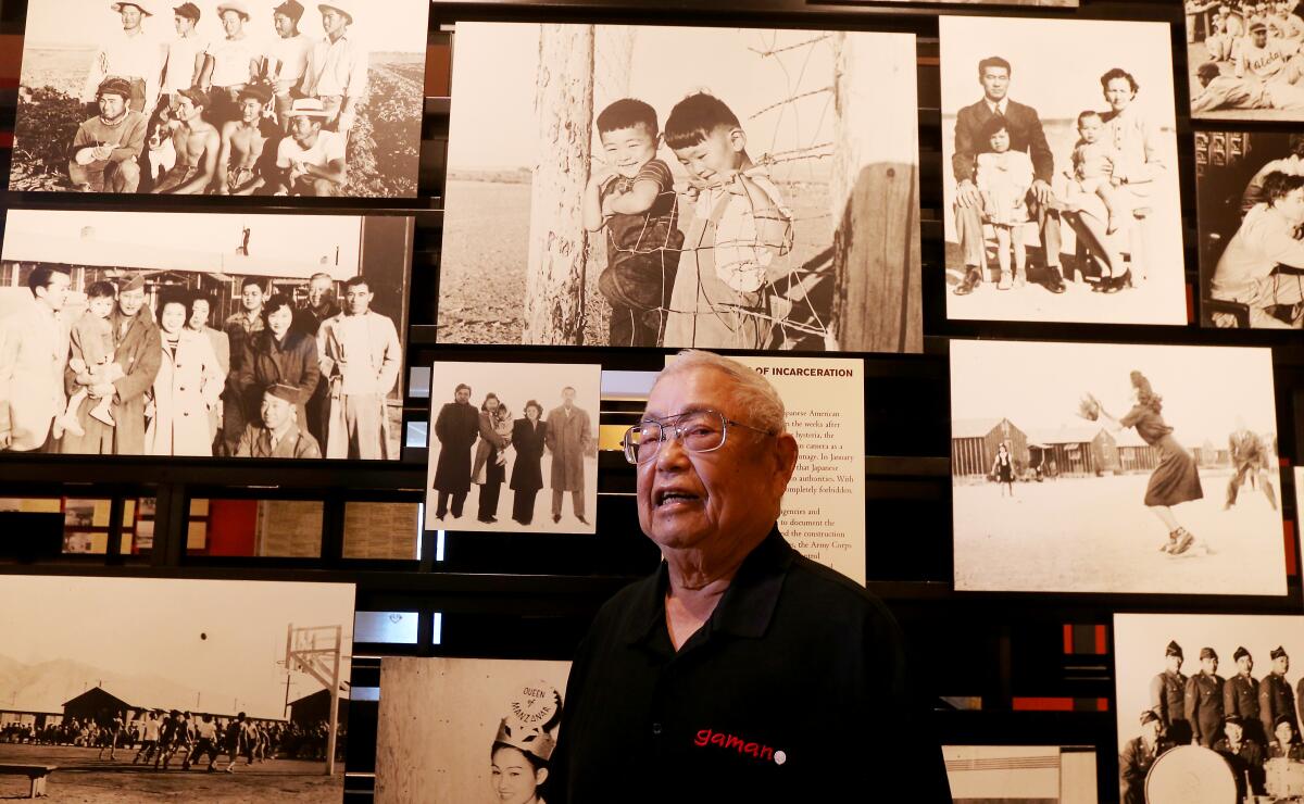 Richard Murakami, 90, with photographs of life in the camps at the Japanese American National Museum in Los Angeles.