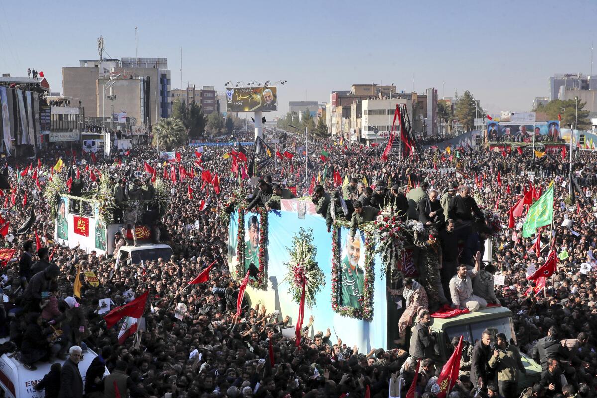 Los ataúdes del general Qassem Soleimani y los demás fallecidos en Irak por un ataque de dron estadounidense son trasladados en camiones rodeados por dolientes durante un cortejo fúnebre en la ciudad de Kerman, en Irán, el martes 7 de enero de 2020.