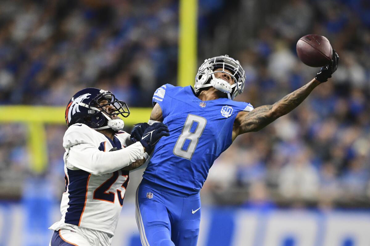 Lions wide receiver Josh Reynolds reaches for a pass while defended by Broncos cornerback Fabian Moreau.