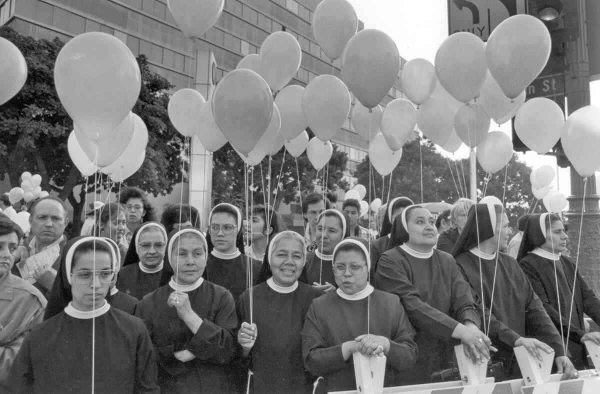 Franciscan sisters from San Fernando patiently wait for Pope John Paul II at 1st and Main streets in Los Angeles in 1987.