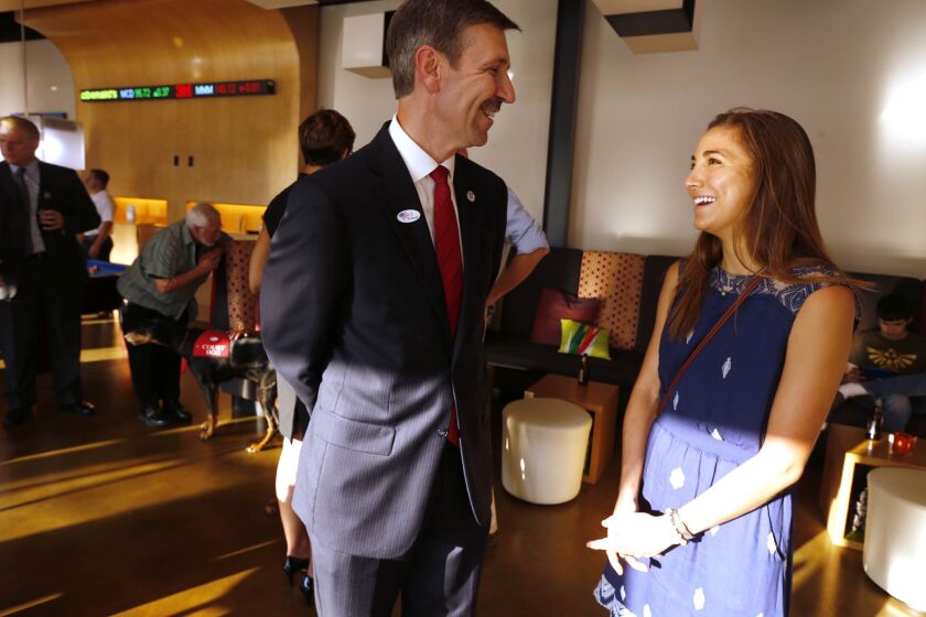 Tulsa District Attorney candidate Steve Kunzweiler, left, chats with his daughter Jennifer Kunzweiler during his watch party in the Republican runoff election on Aug. 26, 2014, in Tulsa, Okla. Kunzweiler was recovering Wednesday, Sept. 28, 2022, at his home in Tulsa, one day after police said he was stabbed by his adult daughter. Jennifer Kunzweiler, 30, was arrested following the stabbing at his home, according to a social media post Tuesday night by Tulsa Police Chief Wendell Franklin. (James Gibbard/Tulsa World via AP)