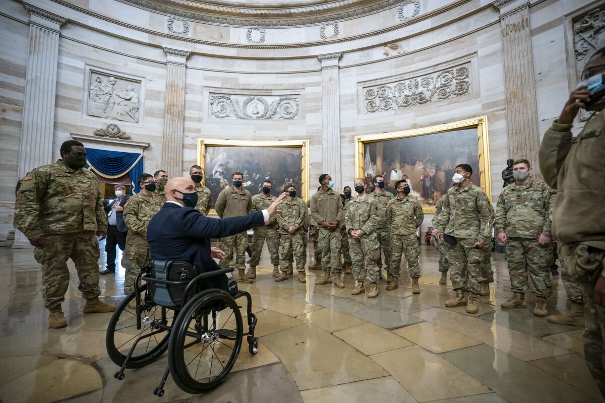 Rep. Brian Mast, R-Fla., left, visits with National Guard troops who are helping with security at the Capitol Rotunda.  