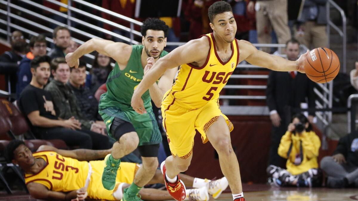 USC's Derryck Thornton (5) steals a ball from Oregon's Ehab Amin (4) during the game on Thursday at Galen Center.