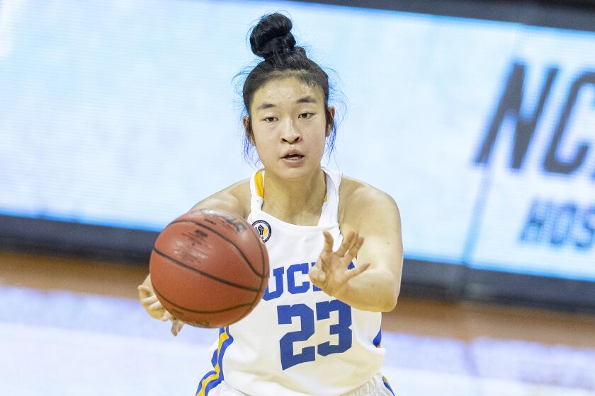 UCLA guard Natalie Chou makes a pass against Wyoming during a college basketball game.