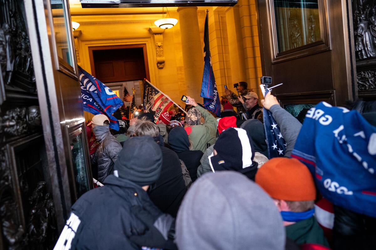 People crowd an entrance to a building.