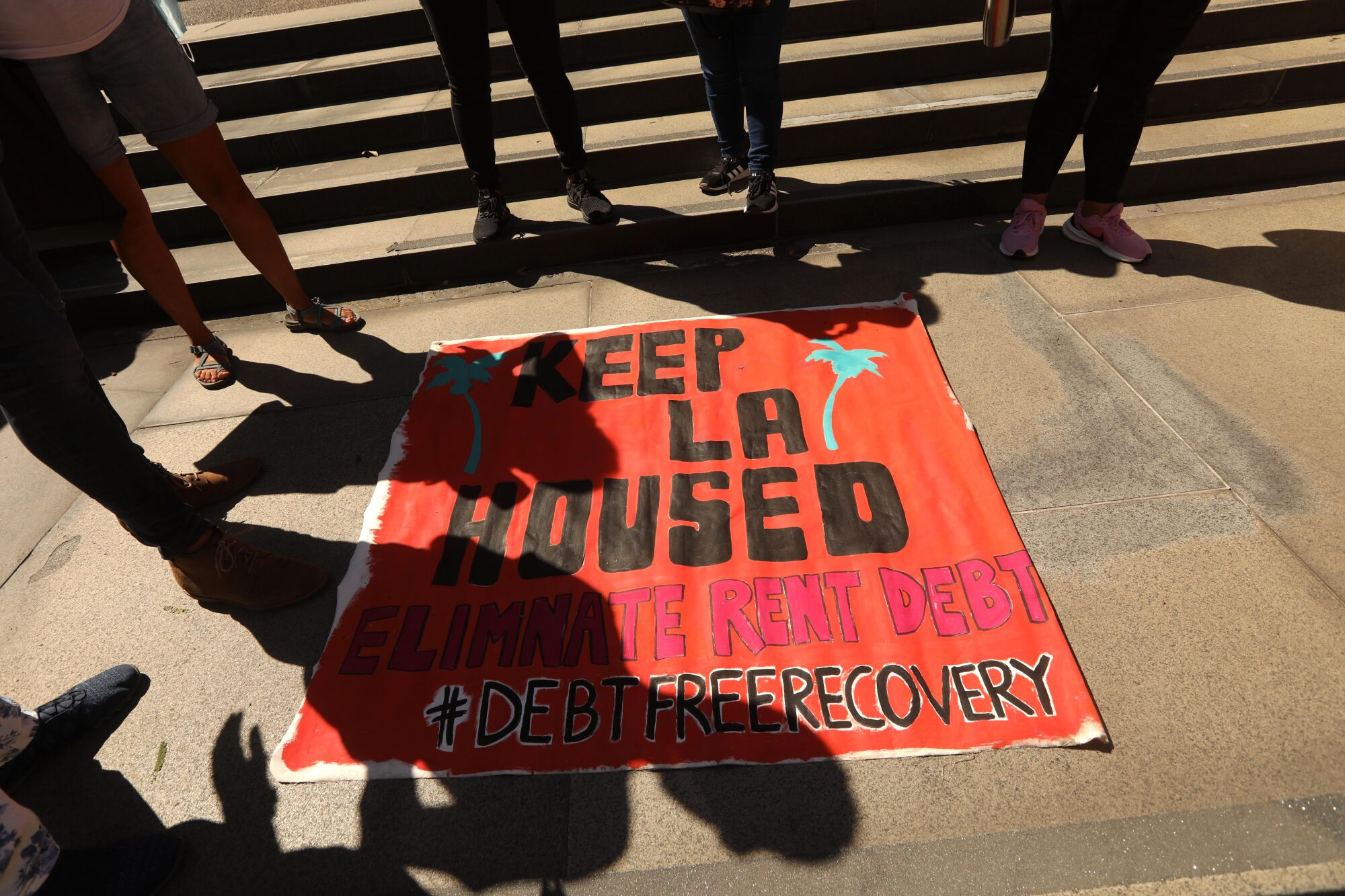 "Keep LA Housed," says a poster as Latino renters made their presence known outside the county Board of Supervisors meeting.