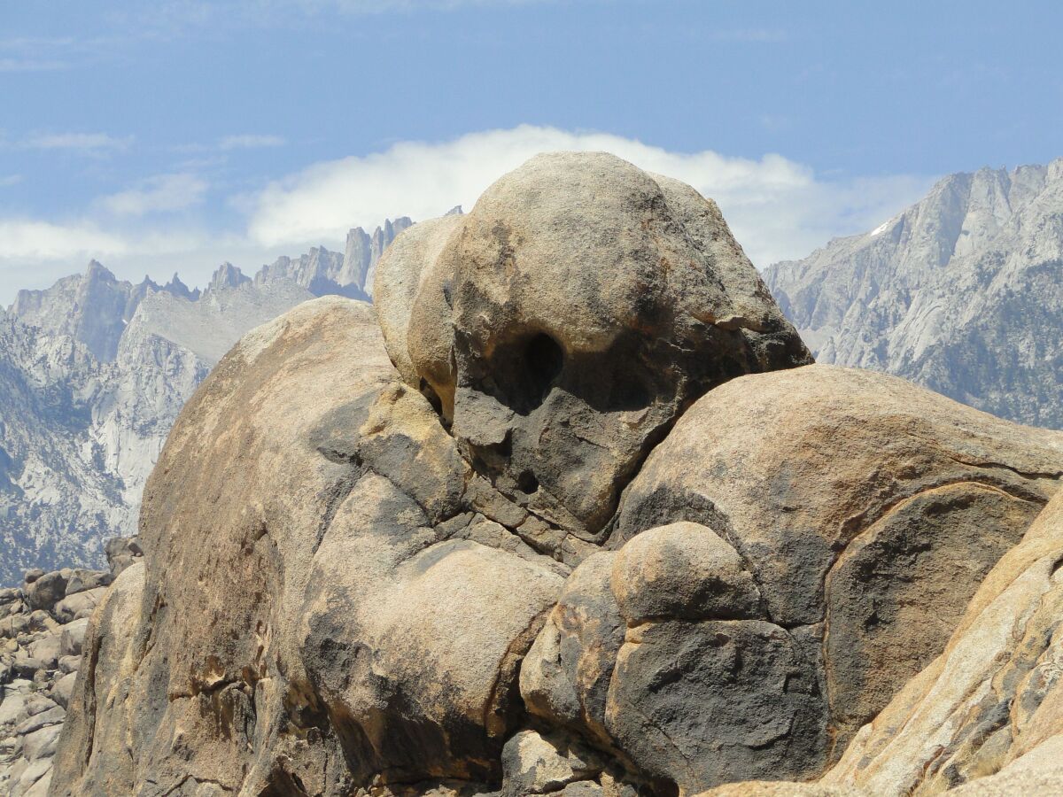 A rock formation somewhat resembles a large head with a face.