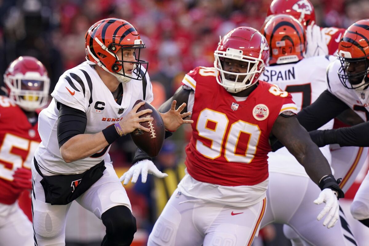 Cincinnati Bengals quarterback Joe Burrow scrambles under pressure from Kansas City Chiefs defensive tackle Jarran Reed.