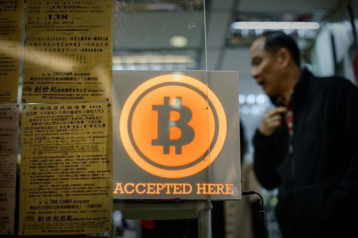The elusive man behind bitcoin may be living in the San Gabriel Valley, according to Newsweek. Above, a Hong Kong store displays a sign saying it accepts the virtual currency.