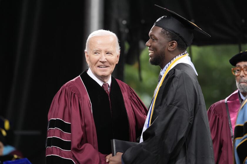 President Joe Biden, left, stands with valedictorian DeAngelo Jeremiah Fletcher at the Morehouse College commencement Sunday, May 19, 2024, in Atlanta. (AP Photo/Alex Brandon)