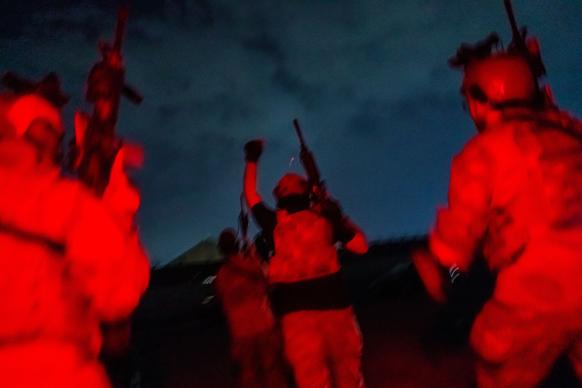 Soldiers seen from behind, lit in red light