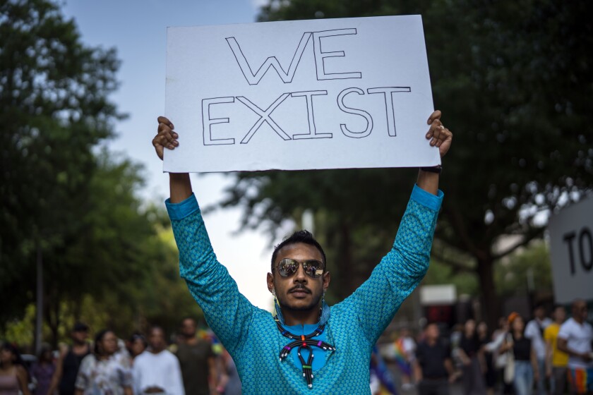 A man holds up a banner during Gay Pride in Johannesburg, South Africa, Saturday Oct. 26, 2019. (AP Photo/Jerome Delay)