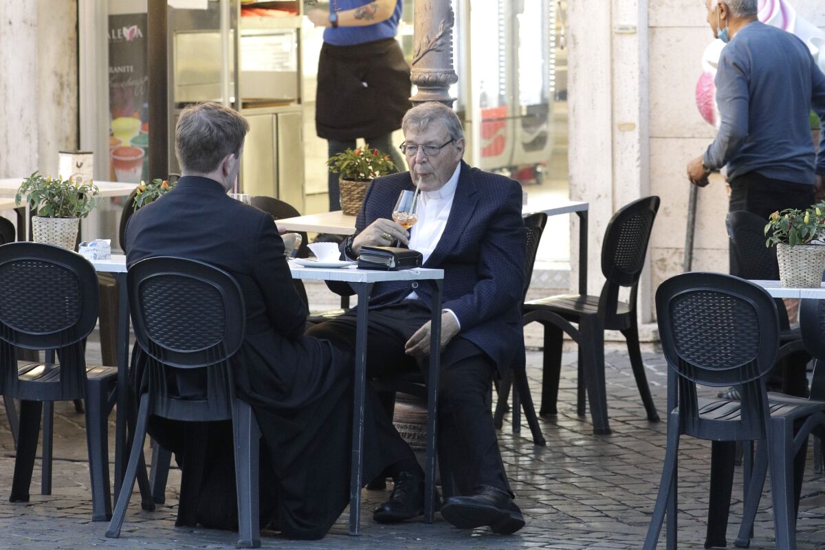 Cardinal George Pell has a drink in a cafe at the Vatican, Sunday, Oct. 4, 2020. Cardinal George Pell, who left the Vatican in 2017 to face child sexual abuse charges in Australia, returned to Rome on Wednesday to find a Holy See mired in the type of corruption scandal he worked to expose and clean up. (AP Photo/Gregorio Borgia)