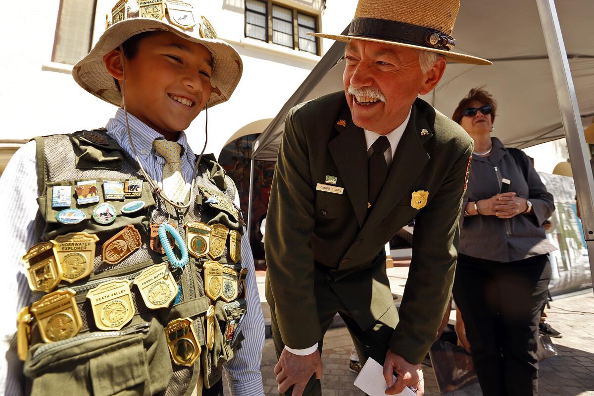 Special programs are planned during National Park Week for Junior Park Rangers like young Tigran Nahabedian, left, who had collected 32 ranger badges when he met National Service Director Jonathan Jarvis last year at the El Pueblo de Los Angeles Historic Monument in L.A.