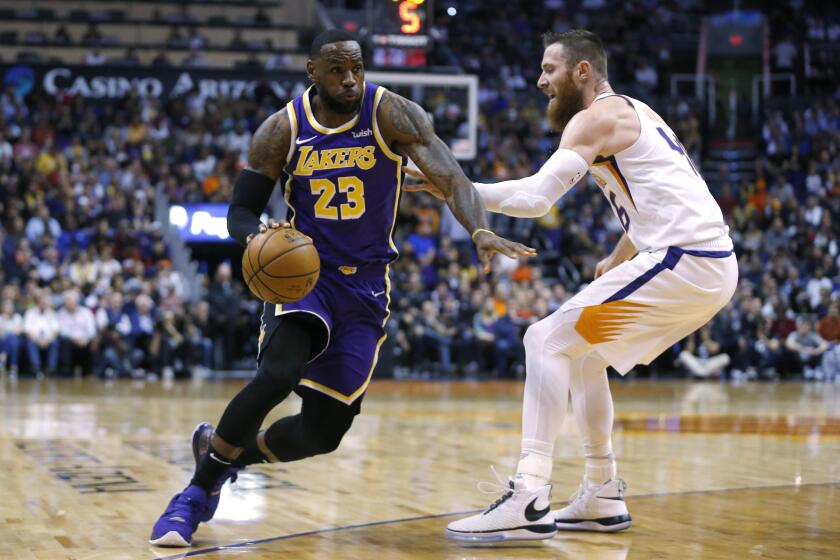Los Angeles Lakers forward LeBron James drives on Phoenix Suns center Aron Baynes (46) in the first half during an NBA basketball game, Tuesday, Nov. 12, 2019, in Phoenix. (AP Photo/Rick Scuteri)