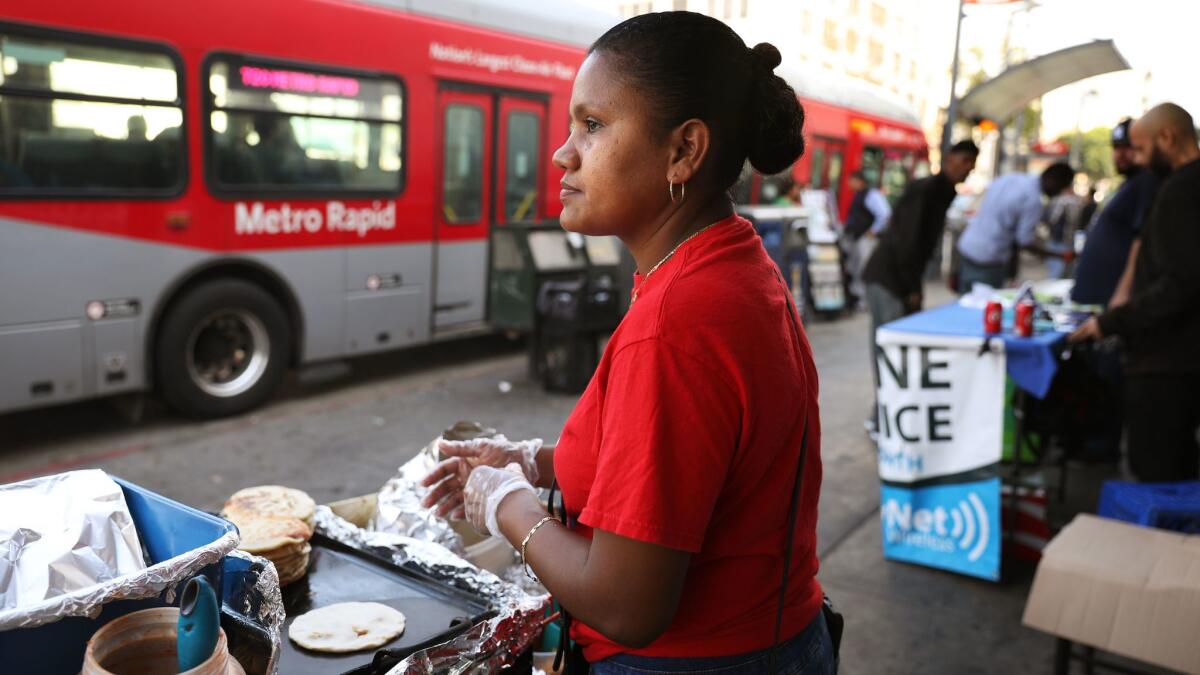 Yesenia Rodriguez, 34, makes pupusas in MacArthur Park. She came to the United States from El Salvador with her son, who is now 16, in 2014.