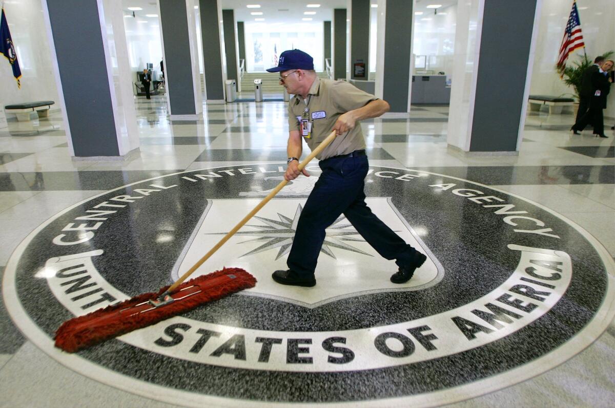 The lobby of the CIA, where an employee sweeps the CIA logo on the floor with a broom. 