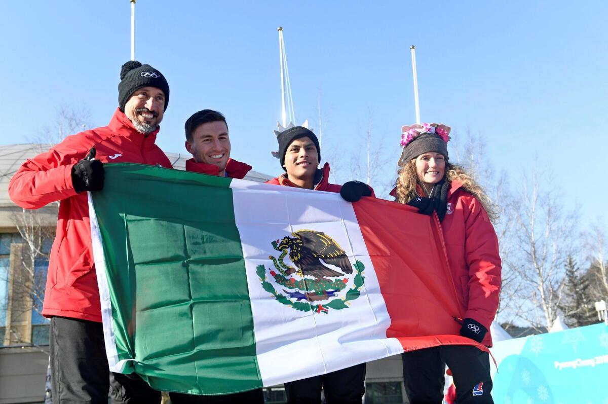 Los miembros del equipo mexicano (de izq a der) el esquiador de fondo Germán Madrazo y los esquiadores alpinos Robert Franco, Roberto Dickson Sommers y Sarah Schleper posan con la bandera durante la ceremonia de bienvenida en la villa olímpica antes del inicio de los Juegos Olímpicos de Invierno de PyeongChang 2018, en Corea del Sur, hoy, 7 de febrero de 2018