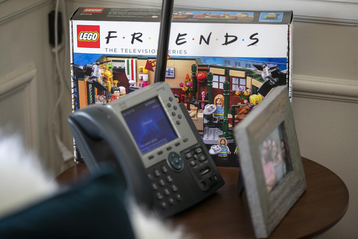 A "Friends" Lego set, landline phone and framed photo on Marta Kauffman's desk.