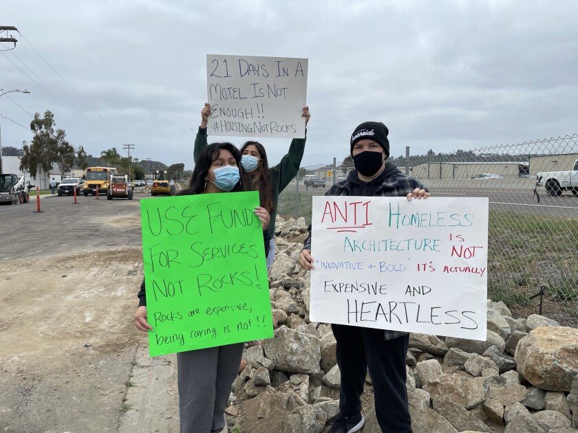 Protesters hold signs at Roymar Road in Oceanside.