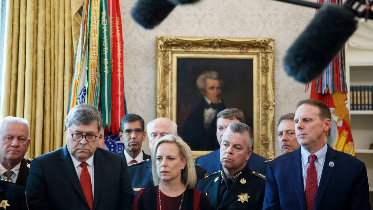 Secretary of Homeland Security Kirstjen Nielsen and Attorney General William Barr listen as President Trump delivers remarks on immigration in Washington on March 15.