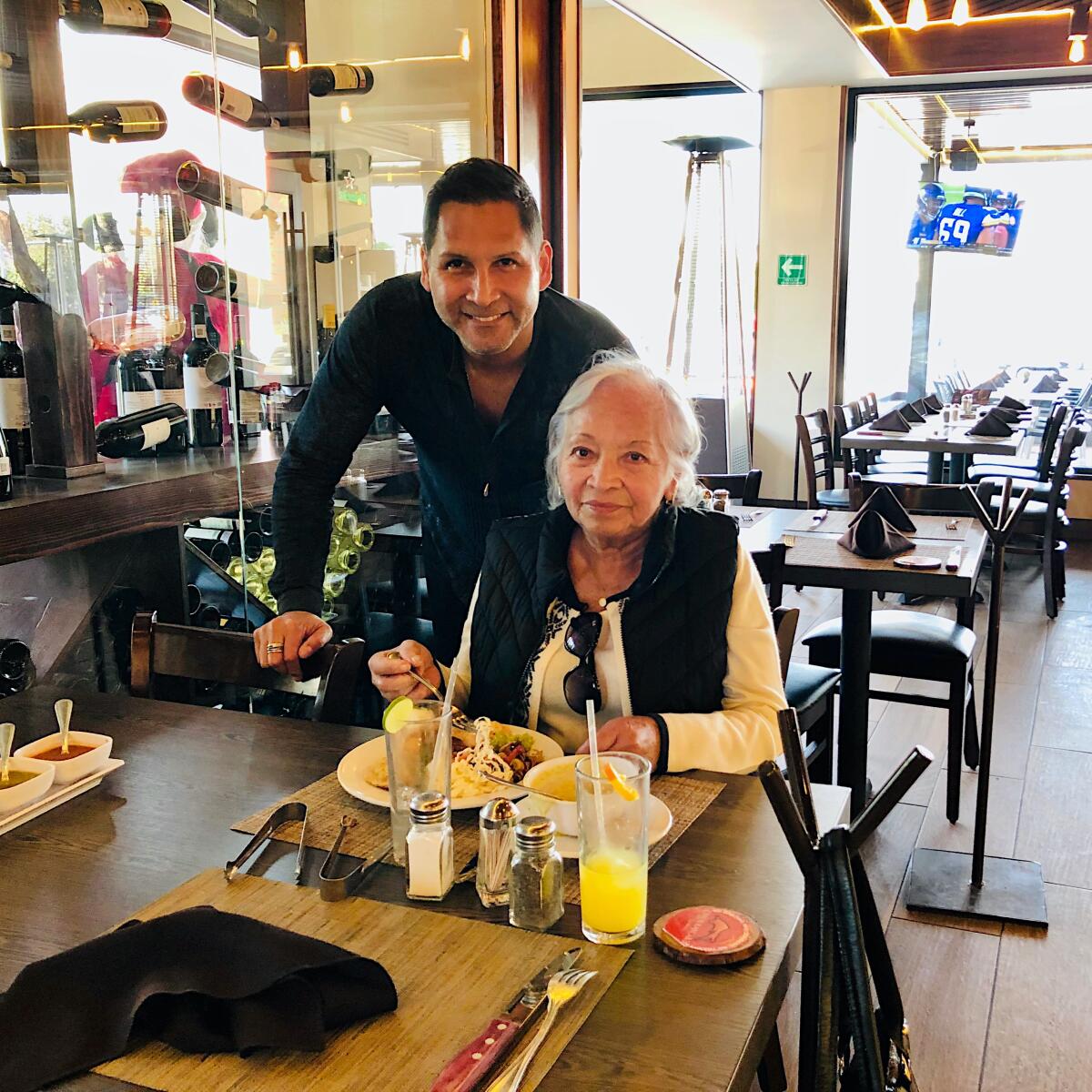 Renzzo Reyes, left, is pictured with his mother, Doris Orozco, at a restaurant.