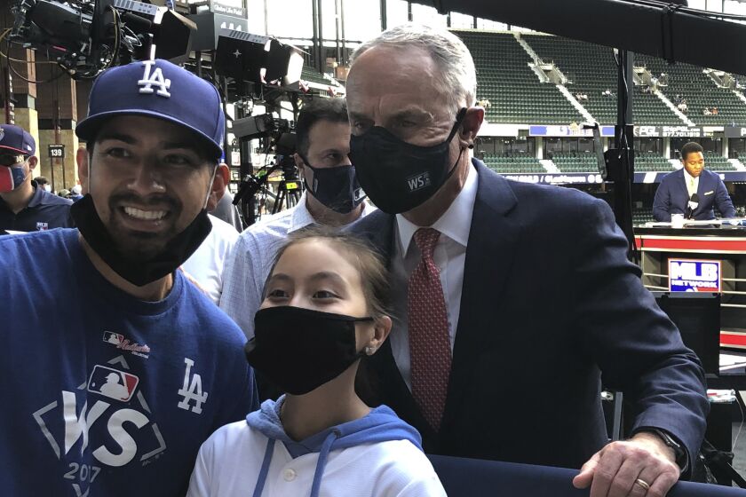 Major League Baseball Commissioner Rob Manfred poses with fans before Game 1.