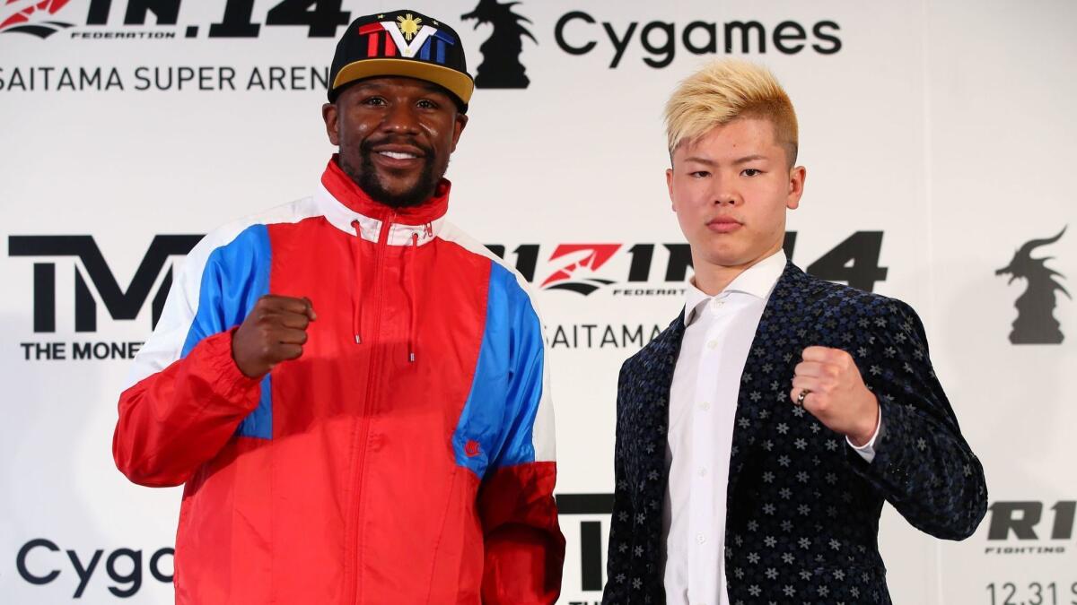 This handout photograph taken by Rizin Fighting Federation shows Floyd Mayweather Jr. (L) posing with his opponent, Japanese kickboxer Tenshin Nasukawa (R) during a press conference.