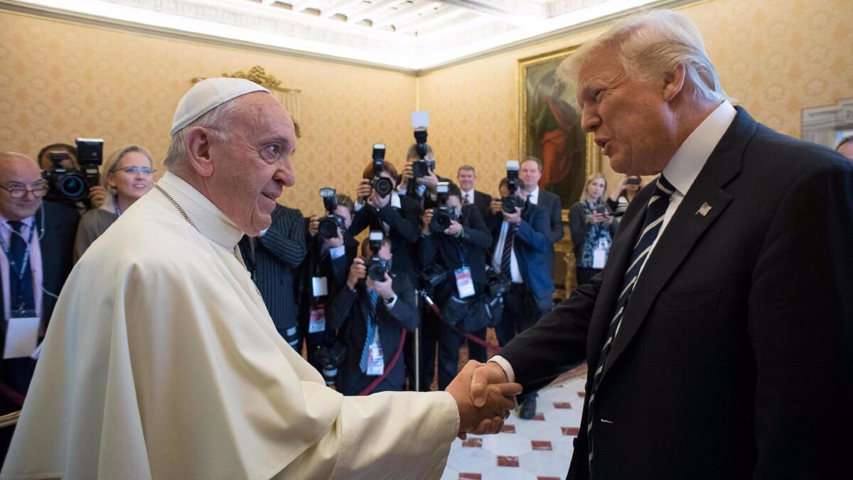 A handout picture provided by the Vatican newspaper L'Osservatore Romano shows Pope Francis, left, meeting with Donald Trump during a private audience at the Vatican on May 24, 2017.
